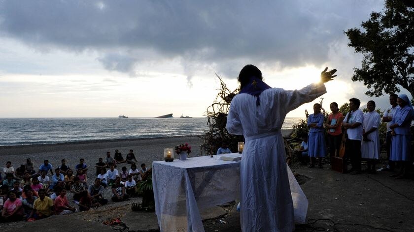 A priest celebrates mass on the beach offered by relatives of victims of Princess of the Stars ferry
