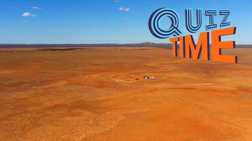 An wide view of an outback Australia location with some small buildings in the middle of dry dessert.