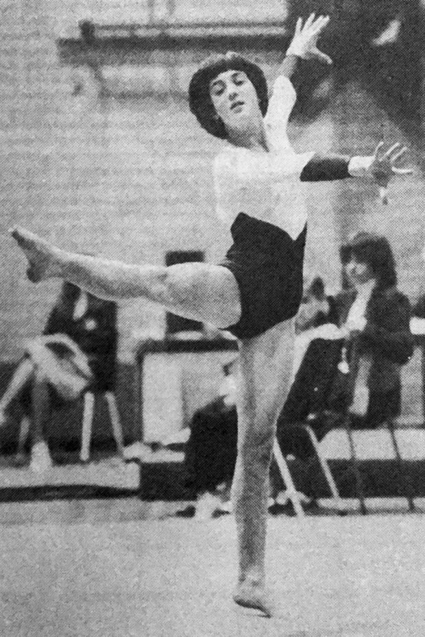 A black and white image of a teenage girl doing gymnastics.