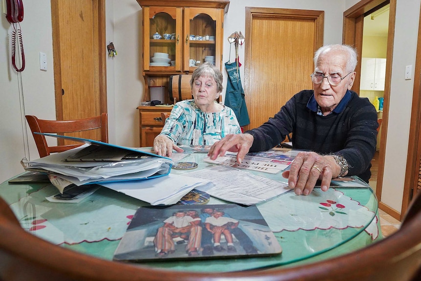 Florence and Bob Thompson at a table with newspaper articles