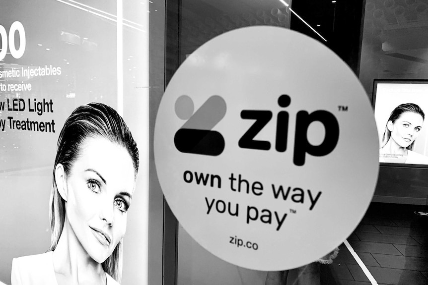 A black and white photo of a Zip sign in a beautician's window.