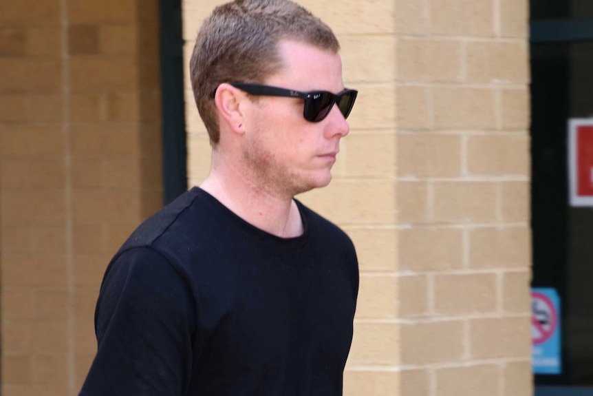 Ben Jayden Malpuss walks outside Joondalup Magistrates Court wearing a black jumper and black sunglasses.