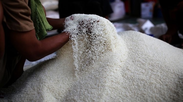 A man holding rice in the market