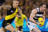 Patrick Dangerfield runs with the ball, while Dustin Martin and a few other players trail in his wake
