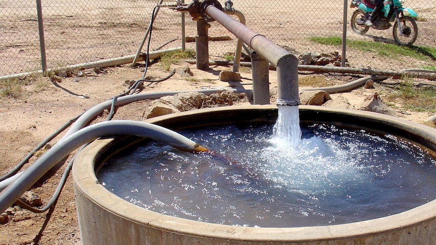 A water bore pours water into a cement trough