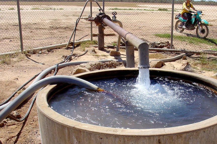 A water bore pours water into a cement trough