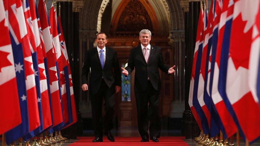 Prime Minister Tony Abbott and his Canadian counterpart Stephen Harper walk down the Hall of Honour.