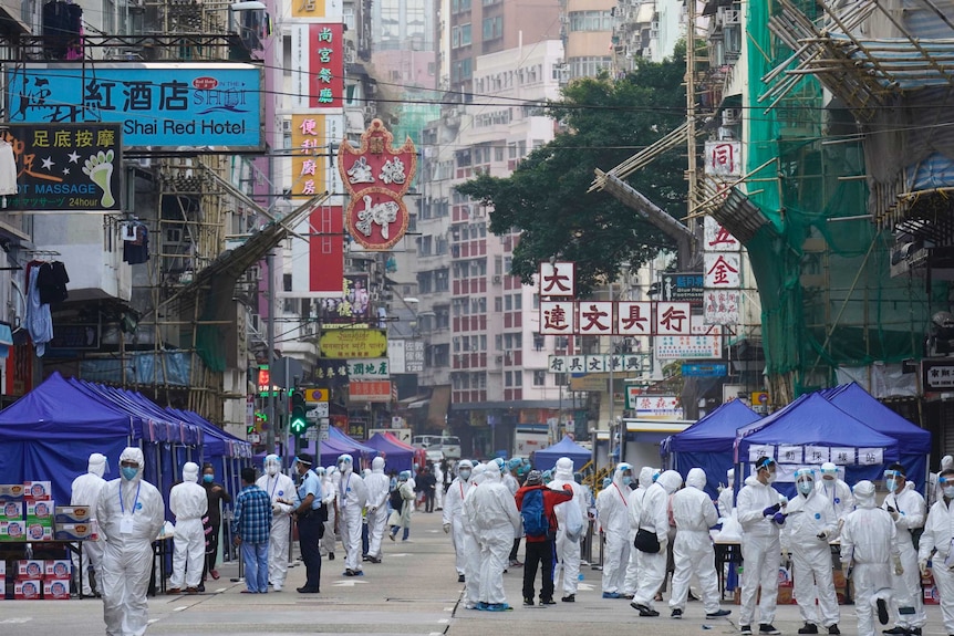 Government investigators wearing protective suits gather in the Yau Ma Tei area in Hong Kong.