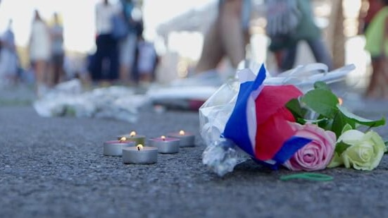 Flowers and candles on a road in Nice, France.