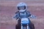 A toddler riding a small motorbike 