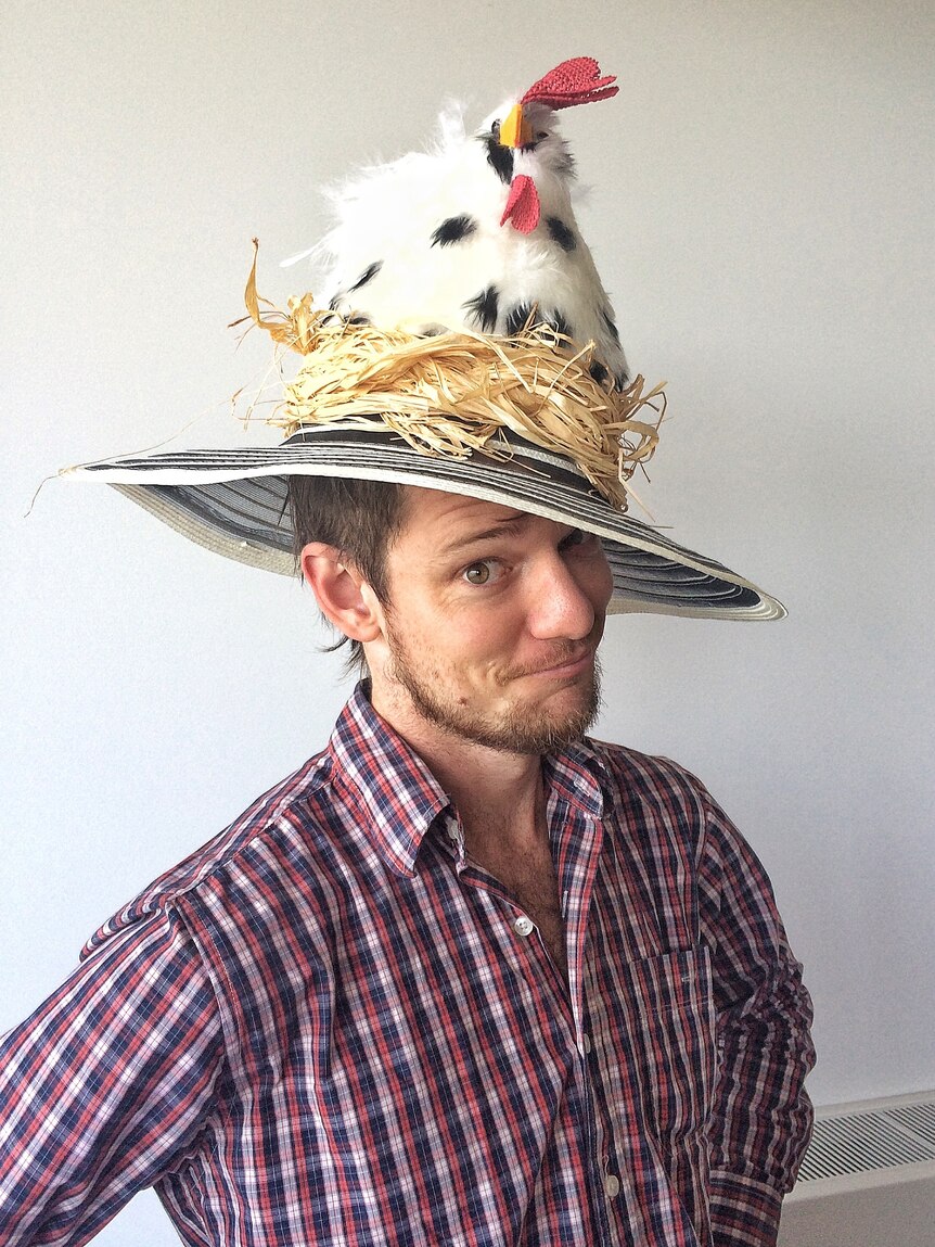 man wearing a hat with a teddy chicken on top