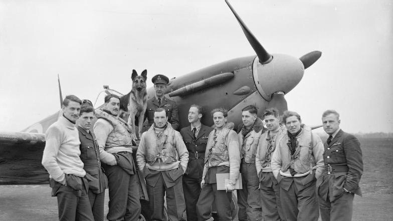 A black and white photo of a spitfire plane and pilots.