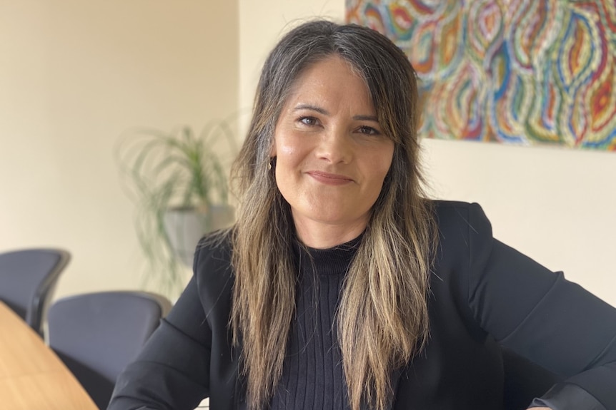 Fiona Endacott sits at a conference table at the Connecting Foster & Kinship Care SA office