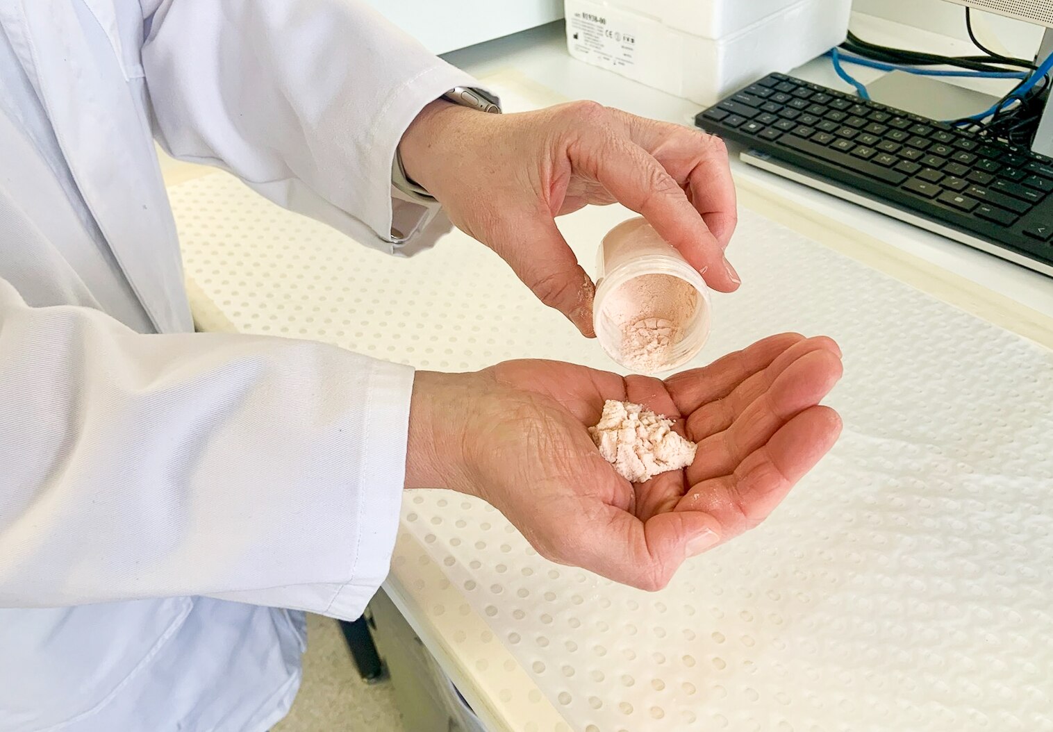 A pink powder in the hand of a scientist