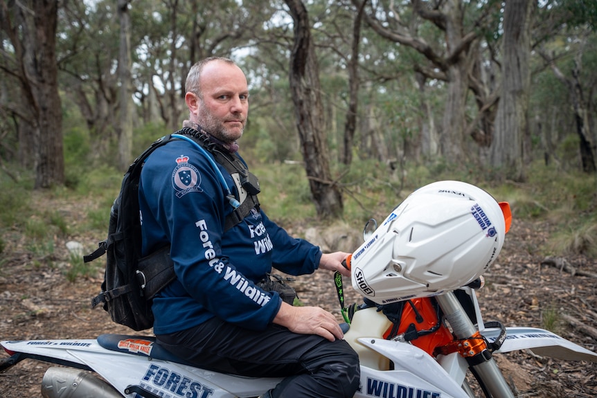 A man in uniform sitting on a dirt bike.