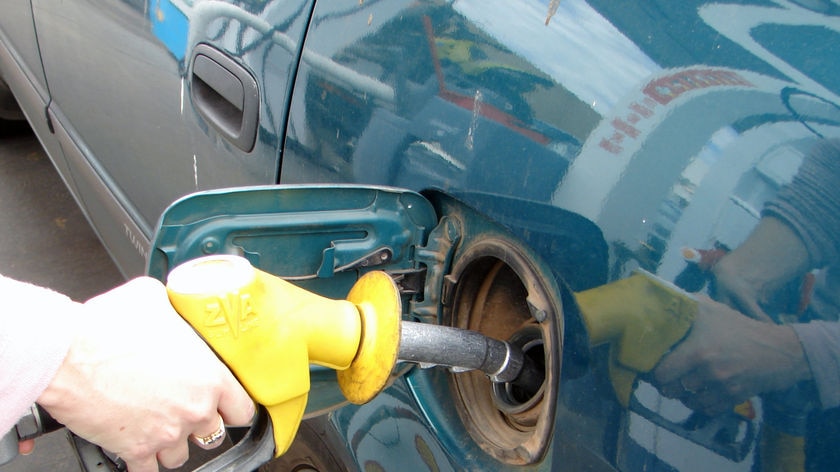 Car being filled with petrol at a service station.