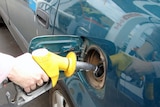 A driver fills up his car at a petrol station