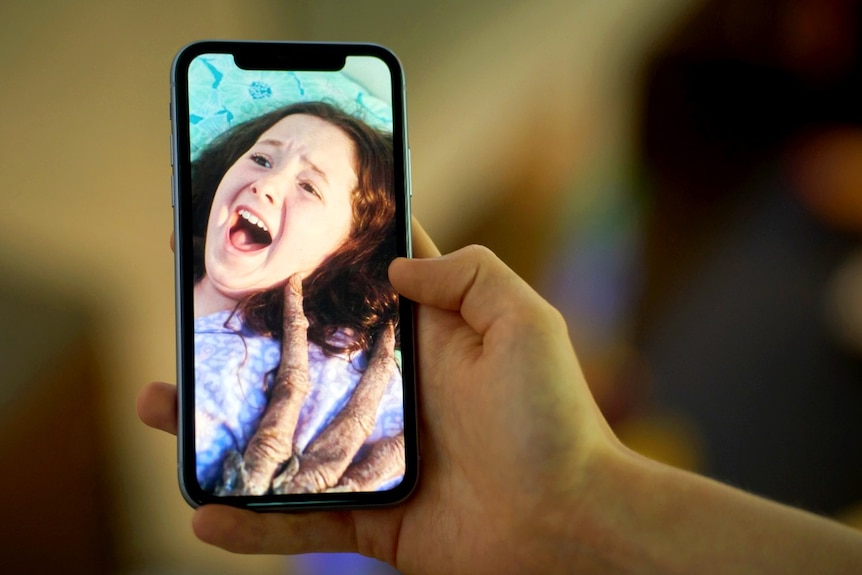 A mobile phone being held in someone's hand, showing a young woman from a TikTok series