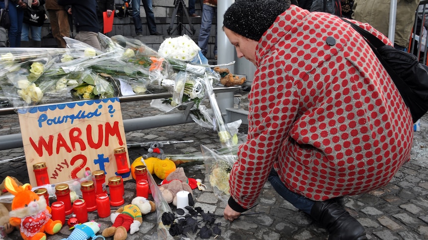 A woman lays flowers at the site of Belgium attack