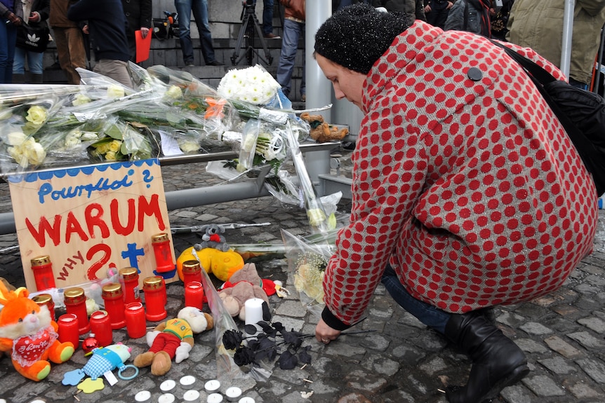 A woman lays flowers at the site of Belgium attack