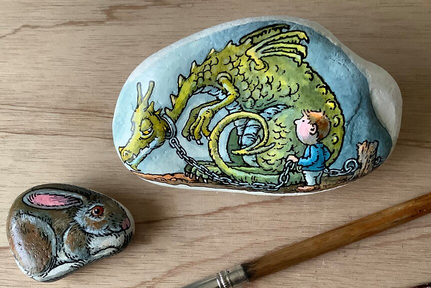 Two rocks, one with a rabbit and the other a dragon with boy