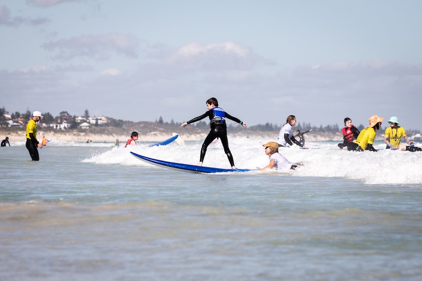 A group of people at the beach with surfboards.