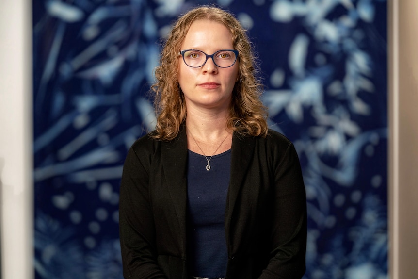 A young white woman with blonde hair and glasses 