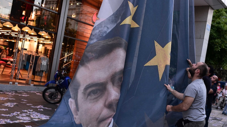 Demonstrators take down EU banner of prime minister Alexis Tsipras