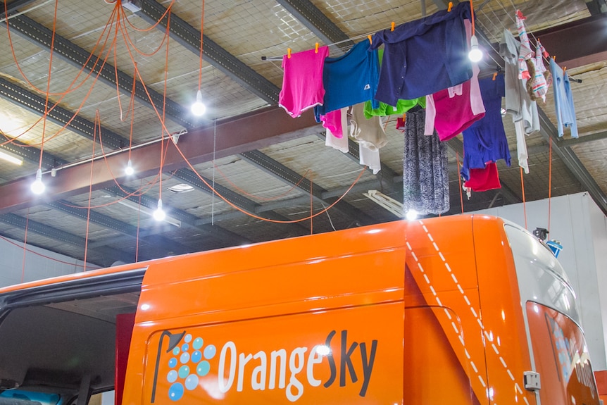 Clothes lines hang from the roof of the Orange Sky Laundry workshop.