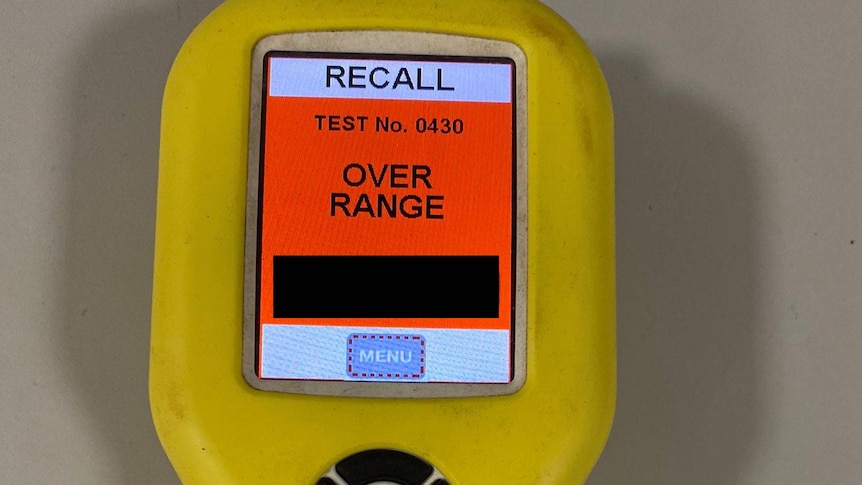 A police breathalyser showing an "over range" reading.