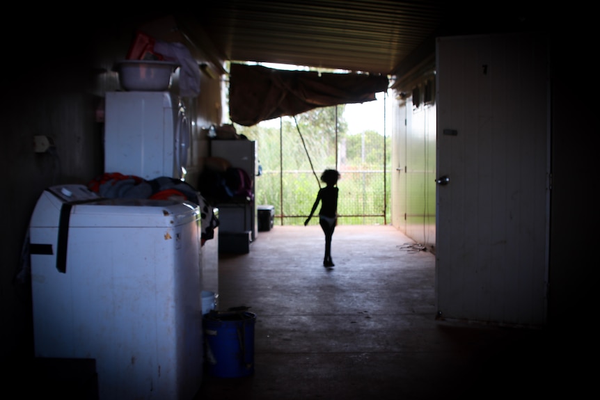 A silhouette of a child walking in a demountable breezeway.