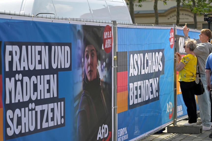 People look through a fence as Maximilian Krah, a member of the European Parliament for the far-right Alternative for Germany, attends a local election campaign rally in Dresden, Germany, on May 1, 2024.