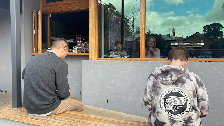 People sitting outside cafe in Orange while others dine inside 