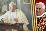 Pope Benedict XVI holds a portrait of late Pope John Paul II