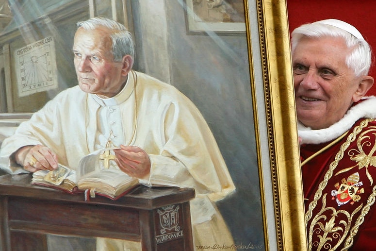 Pope Benedict XVI holds a portrait of late Pope John Paul II