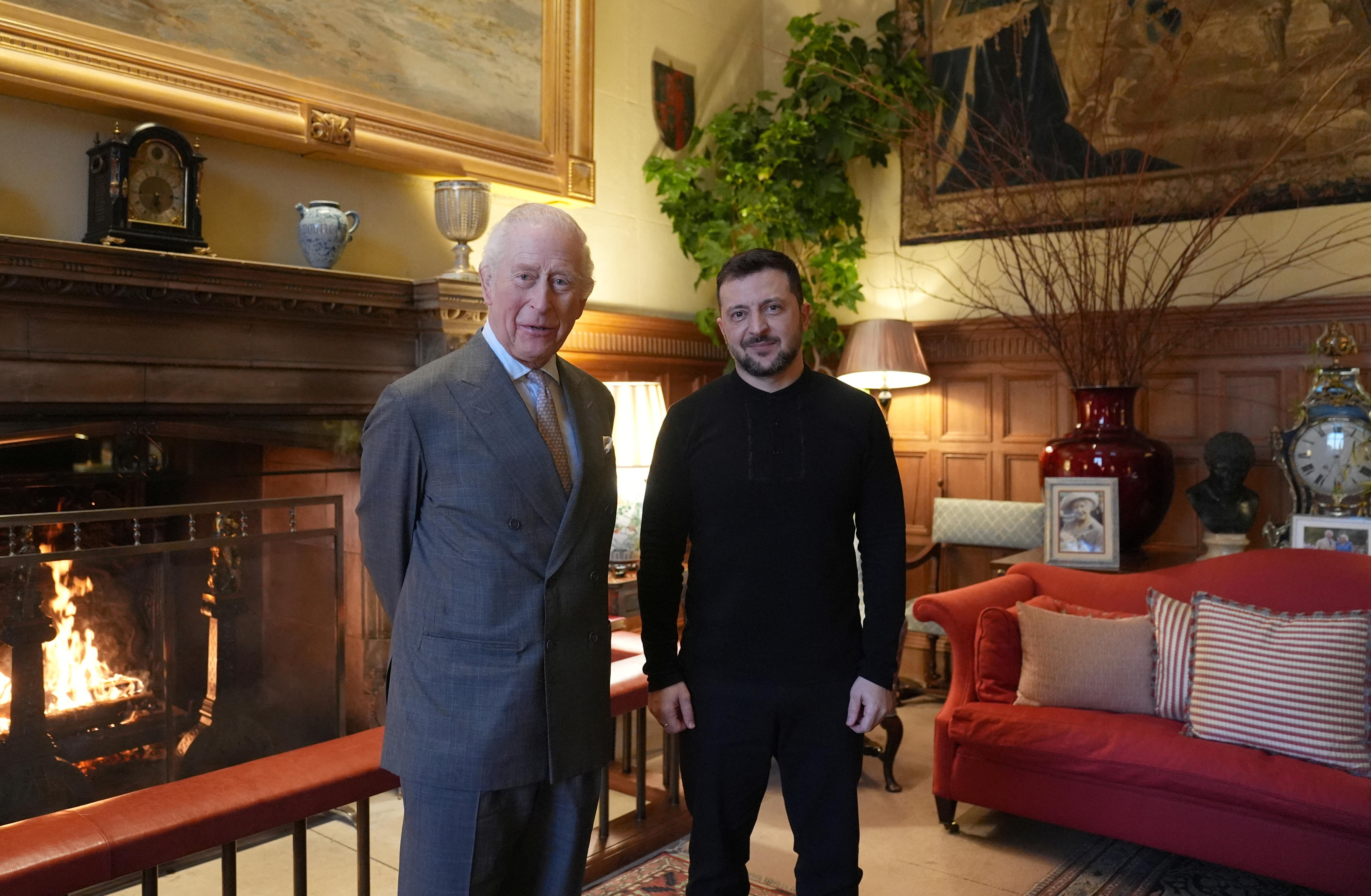 Volodymyr Zelenskyy standing next to King Charles in an ornate dining room.