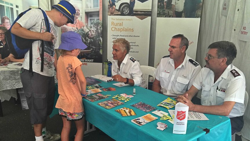 Show chaplains chat with a family in the Salvation Army tent at the Canberra Show.