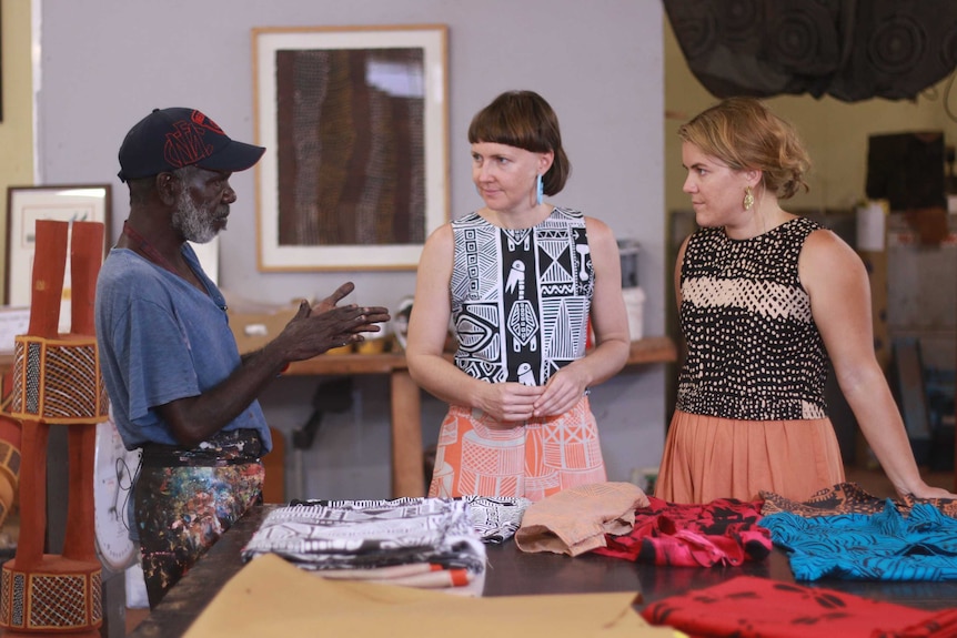 Master Tiwi screenprinter Alan Kerinauia discusses prints with Laura Egan and Maggie McGowan.
