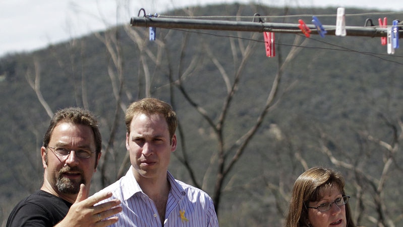 Prince William (centre) chats with bushfire-affected couple Richard and Diane Fox