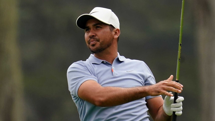 Jason Day looks down the fairway with his club vertically in the air