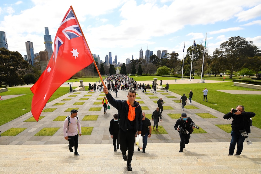 A protester holds the Red Ensign Australian flag during a protest