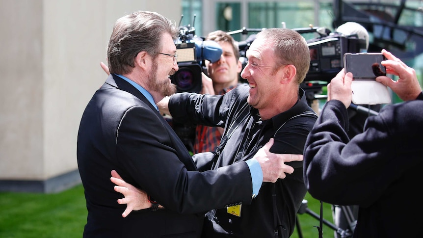 Senator Derryn Hinch embraces Fairfax photographer Andrew Meares on the lawns of Parliament House.