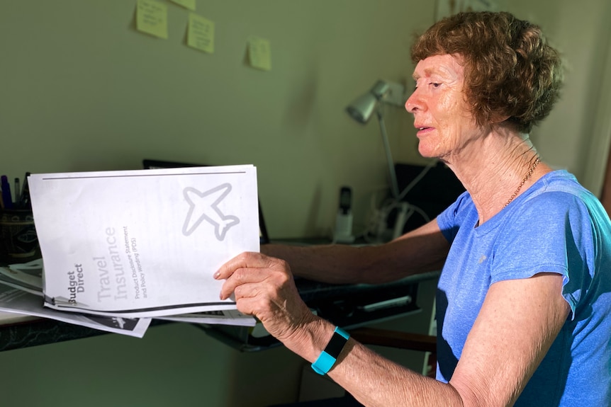 Retiree Gwen Davis-Goff looks through travel insurance documents.