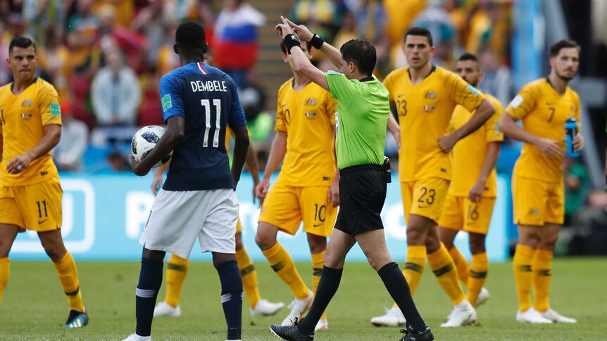 Referee signals for France penalty after consulting VAR against Socceroso