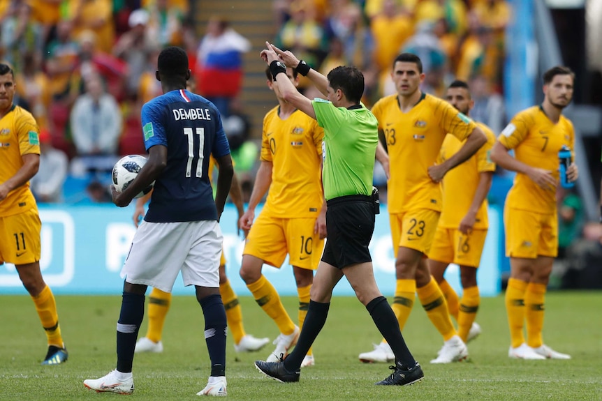 Referee signals for France penalty after consulting VAR against Socceroso