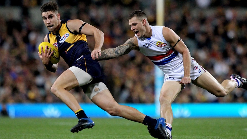 Elliot Yeo of the West Coast Eagles avoids a tackle and runs away from Western Bulldogs player Clay Smith.