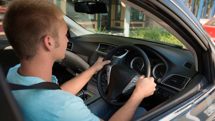 Young man driving a car.