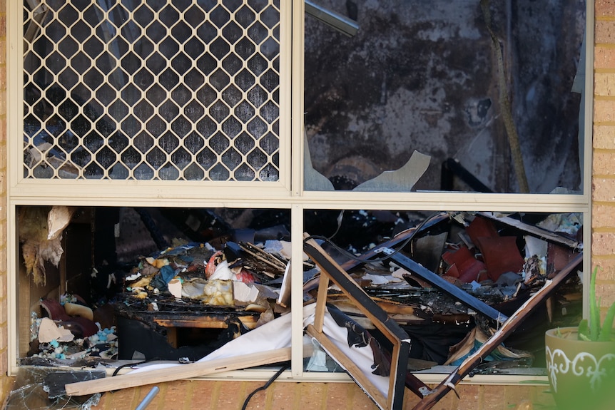 Smashed windows with blackened walls and charred interior.