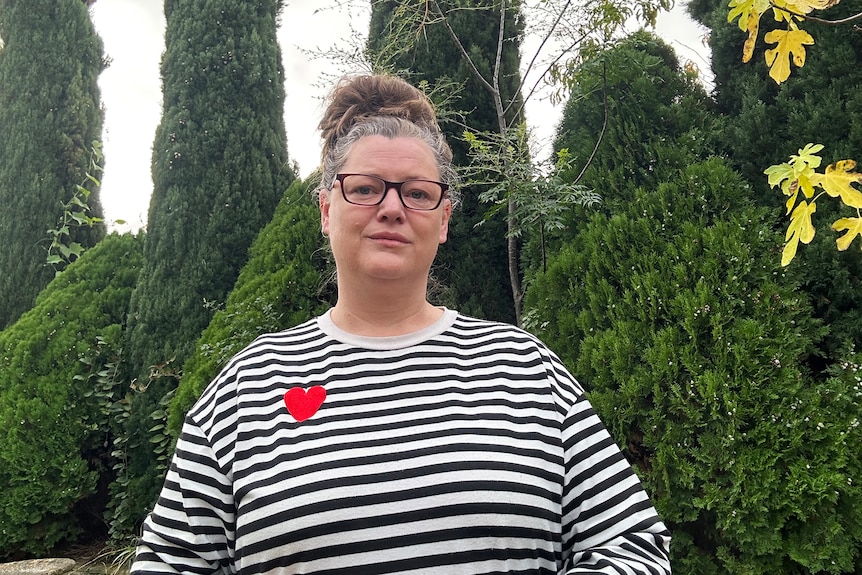 Woman wearing glasses and stripey shirt.