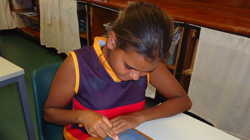 A student cutting the vinyl to make her totem badge.